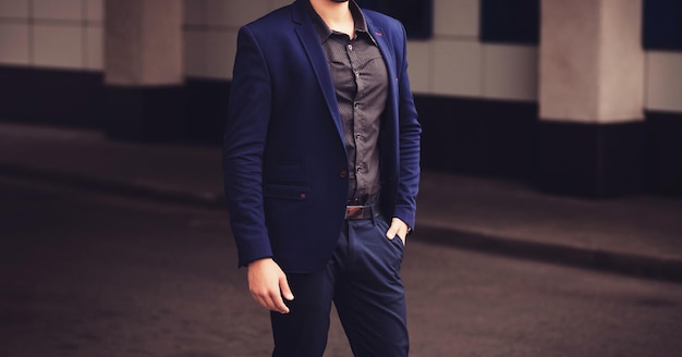 Ritratto di giovane uomo d'affari in background urbano indossando tuta blu professionisti