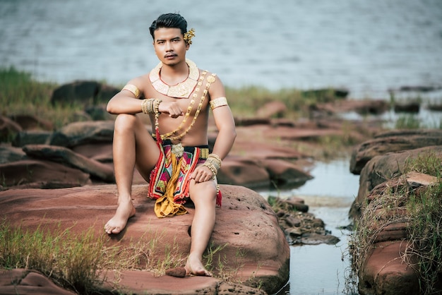 Ritratto di giovane uomo in costume tradizionale in posa in natura in Thailandia