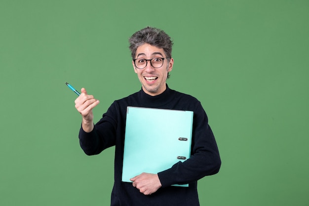 ritratto di giovane uomo in possesso di documenti studio girato su sfondo verde lezione lavoro lavoro insegnante