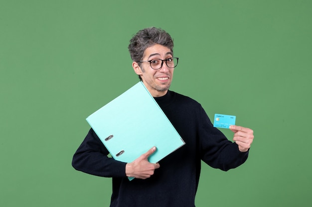 ritratto di giovane uomo in possesso di documento e carta di credito su sfondo verde insegnante denaro maschio lavoro banca