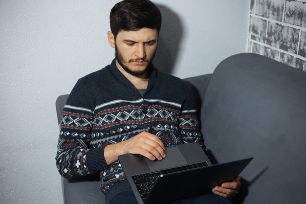 Ritratto di giovane uomo premuroso, lavorando con il computer portatile