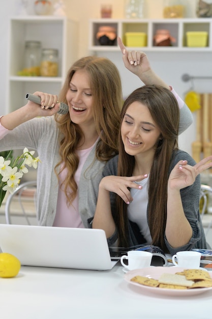 ritratto di giovani donne con microfoni e laptop