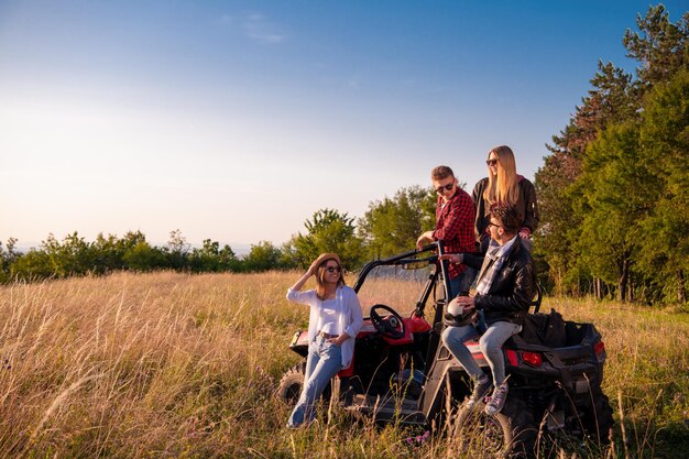 ritratto di giovani felici di gruppo che si godono una bella giornata di sole mentre si guida un'auto buggy fuoristrada sulla natura di montagna