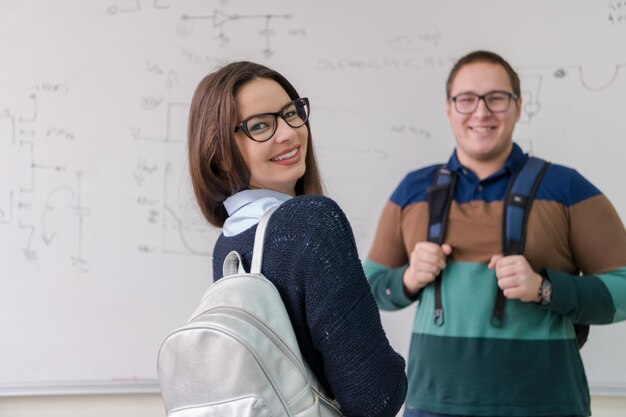 ritratto di gruppo di giovani studenti in piedi davanti alla lavagna bianca e guardando la telecamera