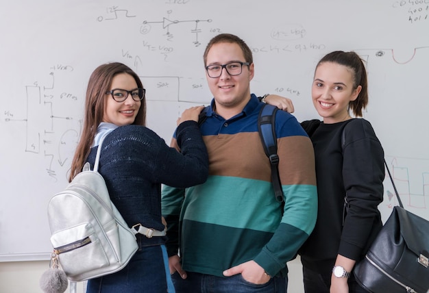 ritratto di gruppo di giovani studenti in piedi davanti alla lavagna bianca e guardando la telecamera