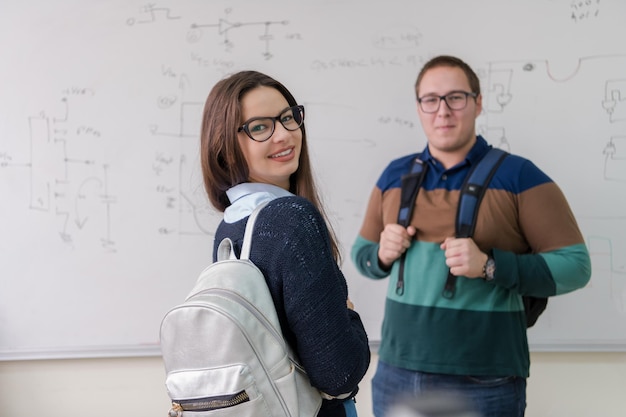 ritratto di gruppo di giovani studenti in piedi davanti alla lavagna bianca e guardando la telecamera