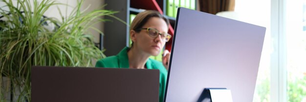 Ritratto di impiegato donna seduto sul posto di lavoro e lavorando utilizzando la tecnologia moderna del pc per