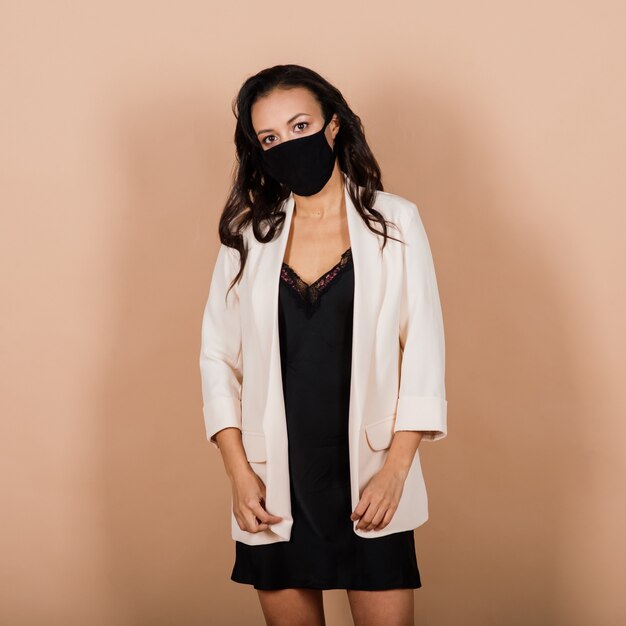 Ritratto di imprenditrice nera che indossa la maschera per il viso durante l'epidemia di virus in uno studio.