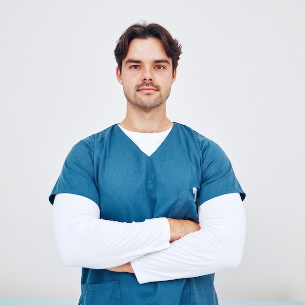 Ritratto di infermiere e uomo con le braccia incrociate per l'assistenza sanitaria in studio su sfondo bianco o spazio mock up Medico di medicina e impiegato professionista con volto serio per la fiducia nel servizio e la carriera