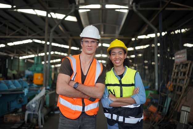 Ritratto di ingegneri maschi e femmine che lavorano nel settore della lavorazione dei metalli. Lavorazione tecnica con tornio presso stabilimento di fabbrica