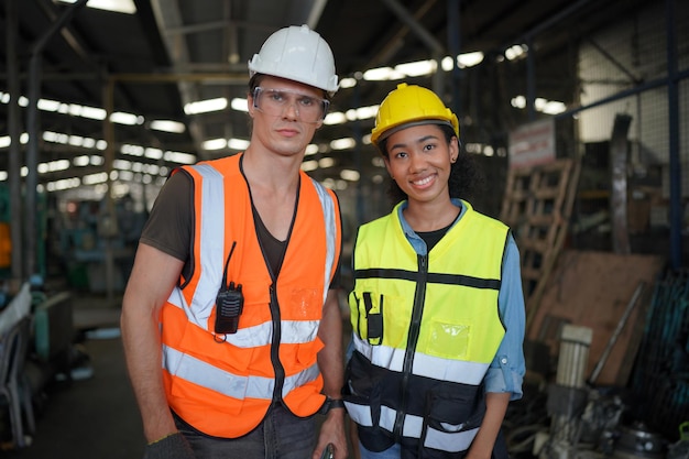 Ritratto di ingegneri maschi e femmine che lavorano nel settore della lavorazione dei metalli. Lavorazione tecnica con tornio presso stabilimento di fabbrica