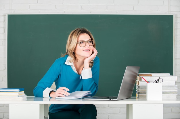 Ritratto di insegnante femminile di insegnante femminile che insegna la linea di studenti delle scuole superiori con il taccuino in cla