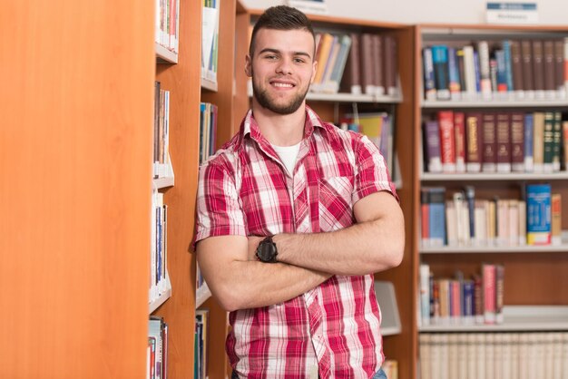 Ritratto di intelligente studente caucasico nella biblioteca del college profondità di campo