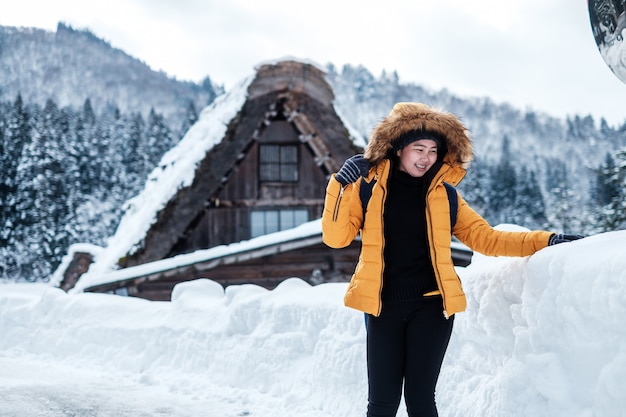 Ritratto di inverno di giovane bella donna asiatica nella neve. Nevicava concetto di moda bellezza invernale