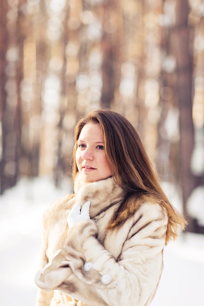 Ritratto di inverno di pelliccia da portare della giovane bella donna. Concetto di moda bellezza inverno neve.