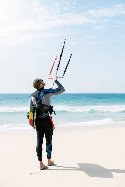 Ritratto di kitesurfer bell'uomo in spiaggia.