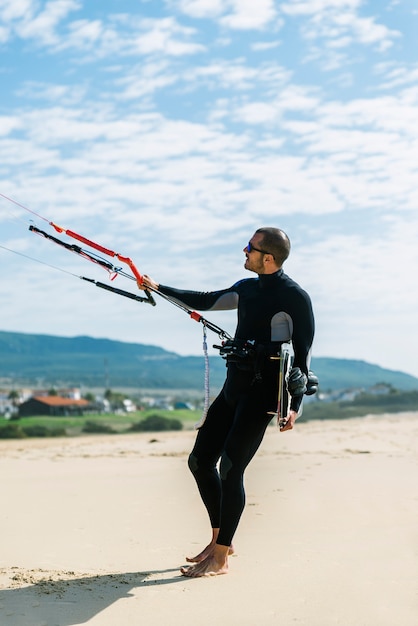 Ritratto di kitesurfer bell'uomo in spiaggia.