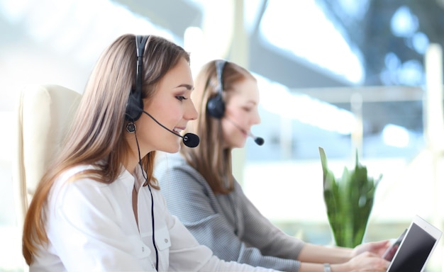 Ritratto di lavoratore del call center accompagnato dal suo team. Operatore sorridente dell'assistenza clienti al lavoro.