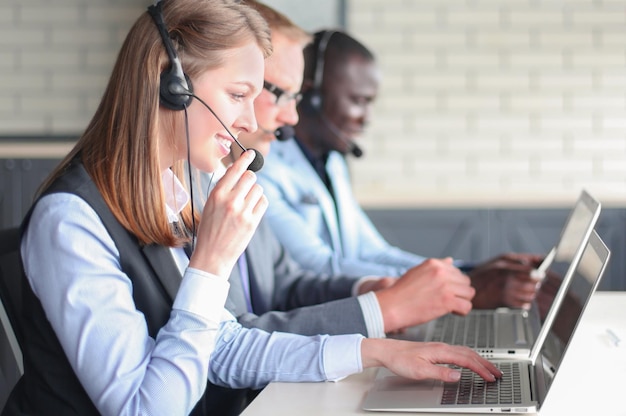 Ritratto di lavoratore del call center accompagnato dal suo team Operatore sorridente dell'assistenza clienti al lavoro