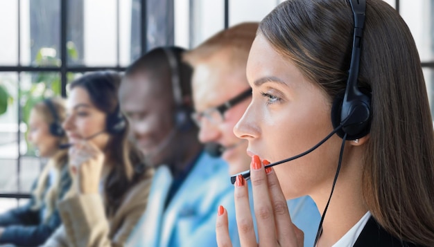 Ritratto di lavoratore del call center accompagnato dal suo team Operatore sorridente dell'assistenza clienti al lavoro