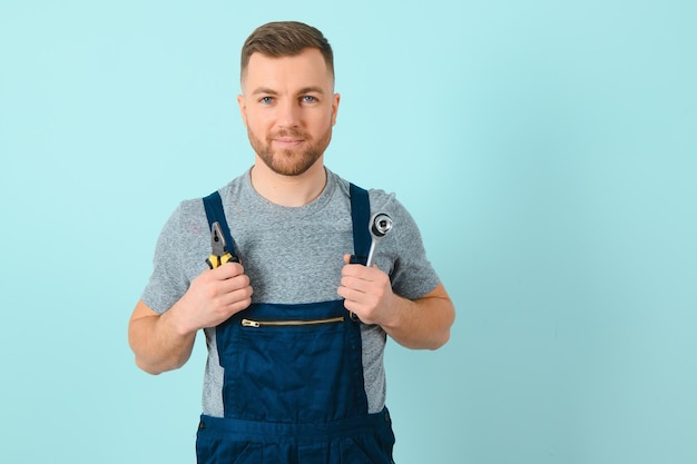 Ritratto di lavoratore sorridente in uniforme isolato su sfondo blu