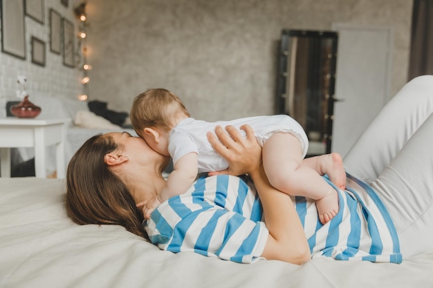 Ritratto di madre e bambino che ridono e giocano a letto a casa