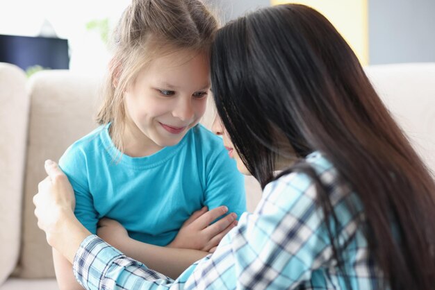 Ritratto di madre e figlia che parlano gentile, figlia di conforto della madre. Il bambino trascorre del tempo con i genitori, la gentilezza e il comfort. Concetto di relazione familiare