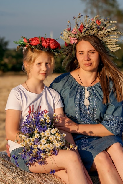 Ritratto di madre e figlia in abiti tradizionali ucraini con ghirlande sulla testa Giorno della Costituzione Festa patriottica Donna e bambino