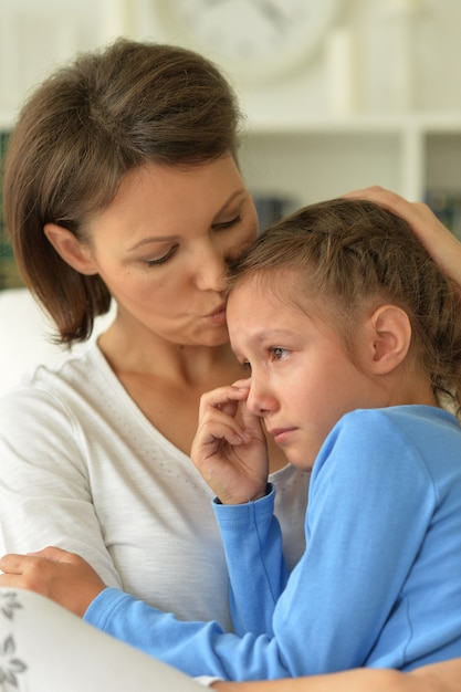 Ritratto di mamma e figlia tristi a casa