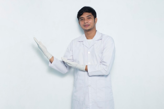 ritratto di medico asiatico che punta con le dita in direzioni diverse isolate su bianco