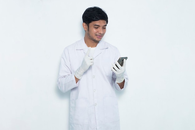 Ritratto di medico asiatico utilizzando il telefono cellulare isolato su sfondo bianco