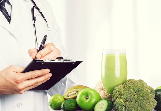 Ritratto di medico con cartella e verdure verdi e frullato