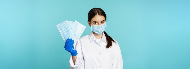 Ritratto di medico donna operaia nel suggerire maschere facciali dalla pandemia covid in piedi in hos