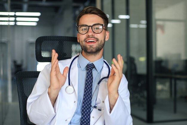 Ritratto di medico eccitato sorridente in ospedale.