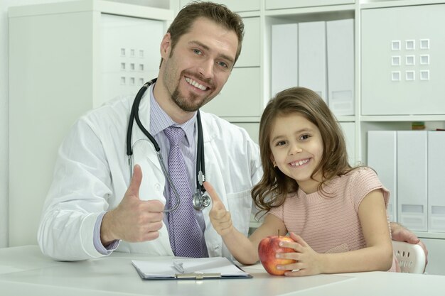 Ritratto di medico maschio con bambina in ospedale office