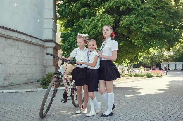 Ritratto di moda felice ragazzini divertendosi con la bici in città.