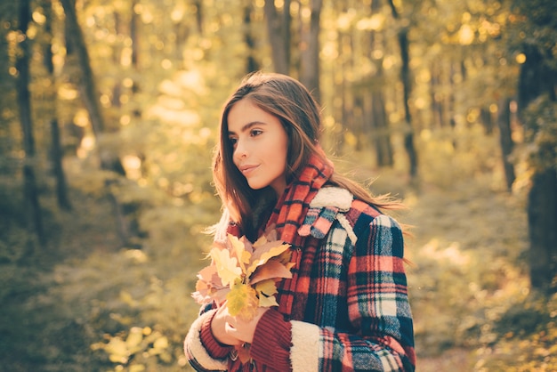 Ritratto di moda stile di vita all'aperto di bella giovane donna che cammina sul parco in autunno. Foto di moda atmosferica all'aperto di giovane bella signora nel paesaggio autunnale