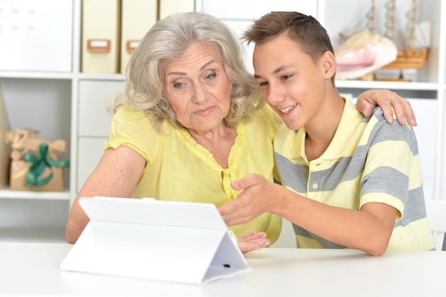 Ritratto di nipote e nonna che utilizzano tablet a casa