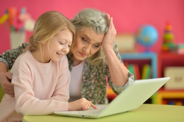 Ritratto di nonna e figlia felici che usano il computer portatile