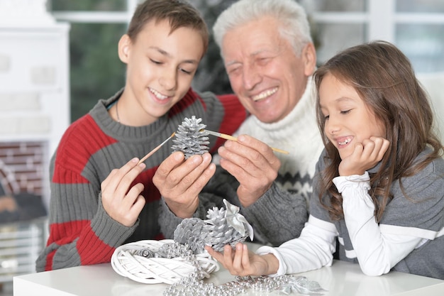 Ritratto di nonno felice con i bambini che si preparano per il Natale insieme