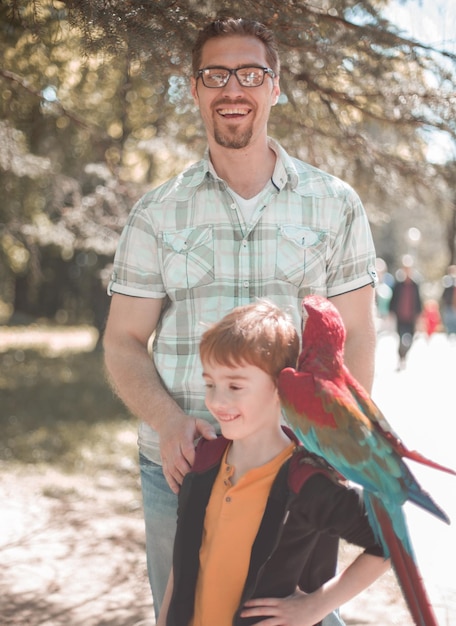 Ritratto di padre e figlio con foto di pappagalli ara al parco divertimenti