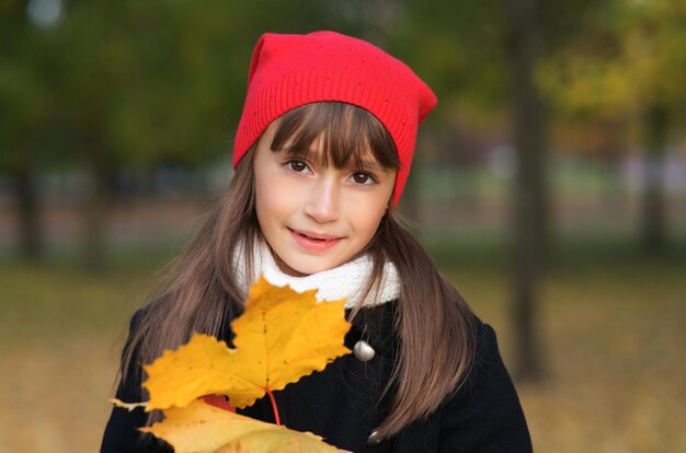 Ritratto di piccola ragazza carina bel bambino in cappello che cammina al parco autunnale dorato