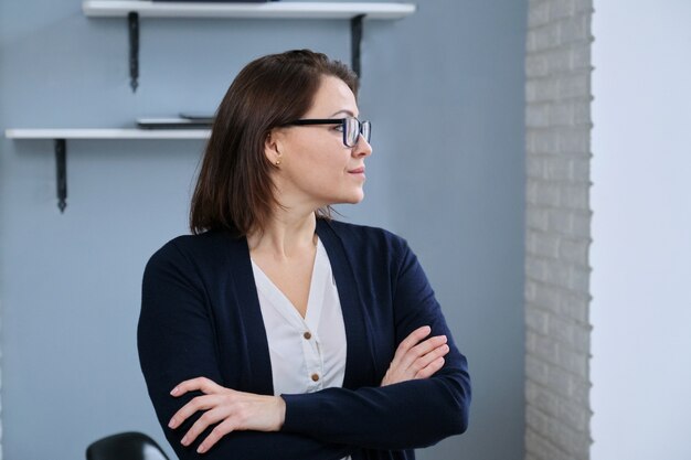 Ritratto di positivo fiducioso donna matura con le braccia piegate,