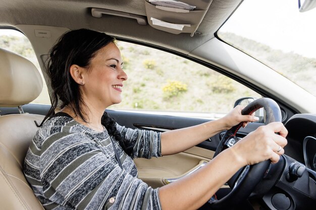 Ritratto di profilo di una donna sorridente durante la guida