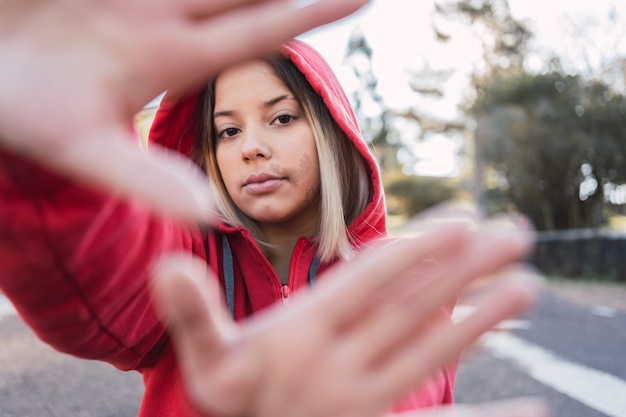 Ritratto di ragazza adolescente con una voglia sul viso con le mani davanti al viso.