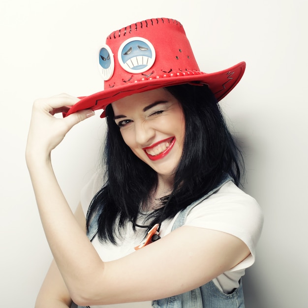 Ritratto di ragazza alla moda Hipster in Red Hat, girato in studio