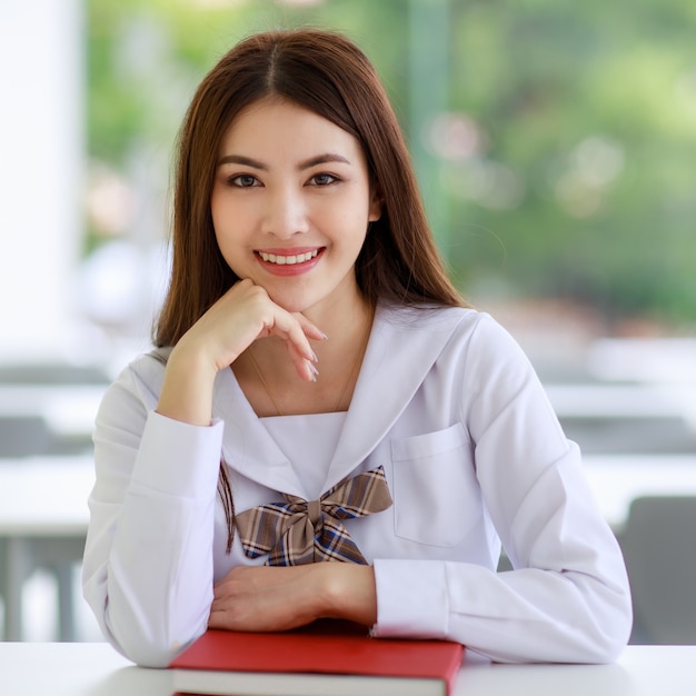 Ritratto di ragazza asiatica carina e giovane, etnia Lao, che indossa l'uniforme da scolaretta in stile giapponese.