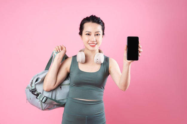 Ritratto di ragazza asiatica fitness, isolato su sfondo rosa