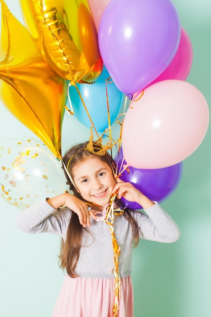 ritratto di ragazza bambino abbastanza gioioso sulla festa di compleanno con palloncini