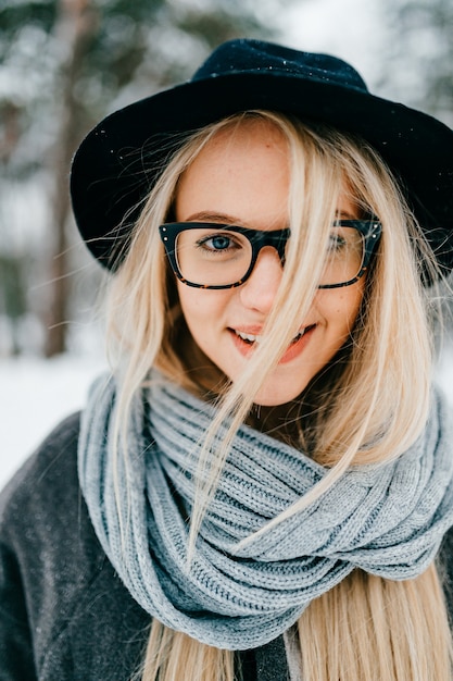 Ritratto di ragazza bionda abbastanza elegante in cappello e occhiali